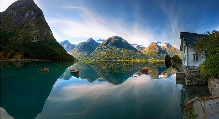 Montañas reflejadas en las aguas tranquilas de un fiordo noruego