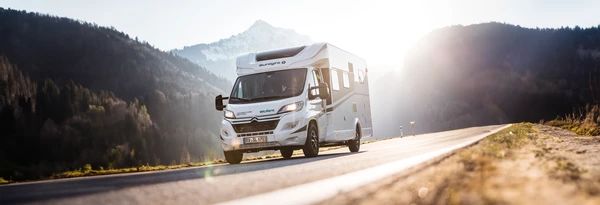Autocaravana en una carretera de montaña a contraluz