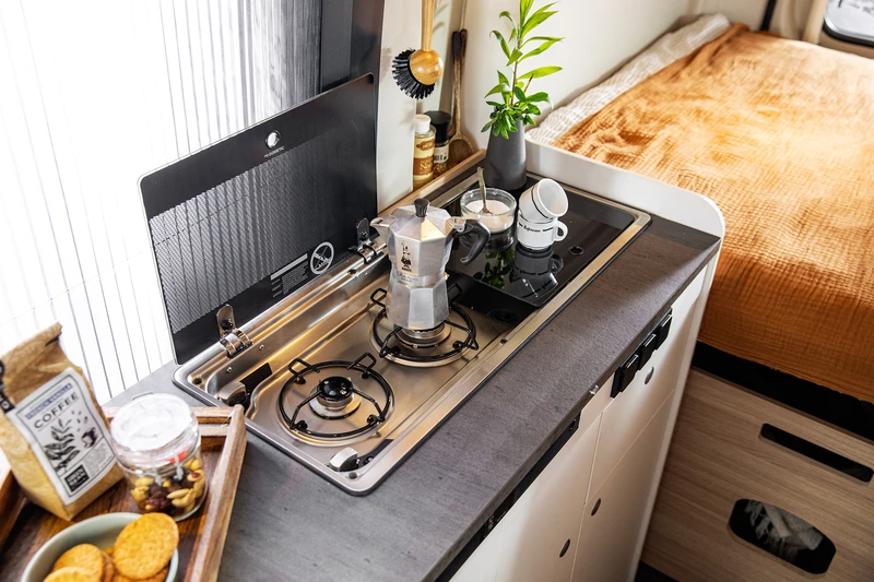 Cuisine avec plaque au gaz et évier à l’intérieur d’un van aménagé