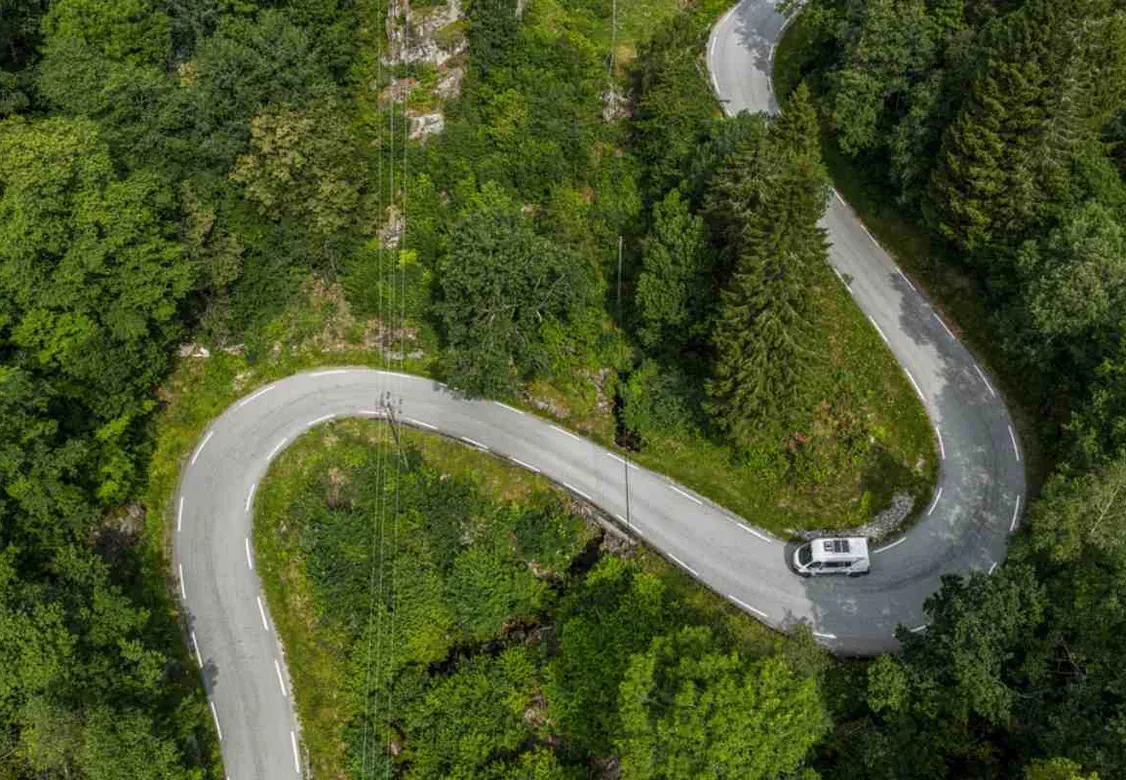 Vue aérienne d’un camping-car sur une route sinueuse en forêt