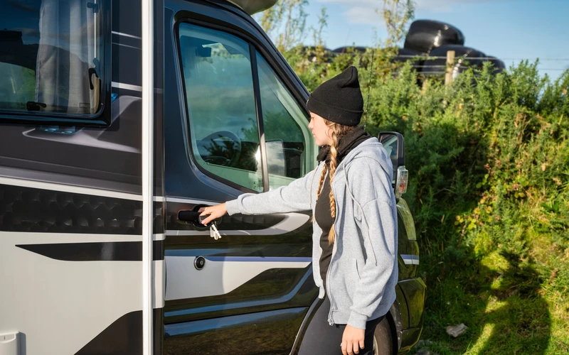 Voyageuse ouvrant la porte d'un camping-car