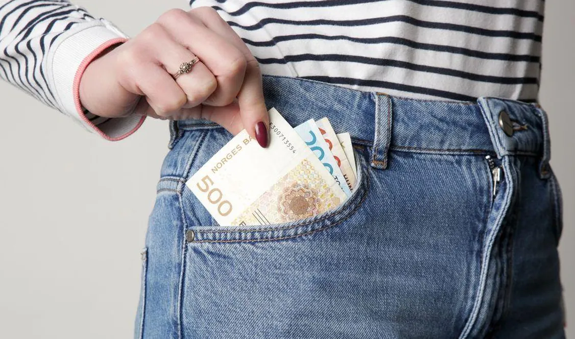 Billets en couronnes norvégiennes glissés dans une poche de jean