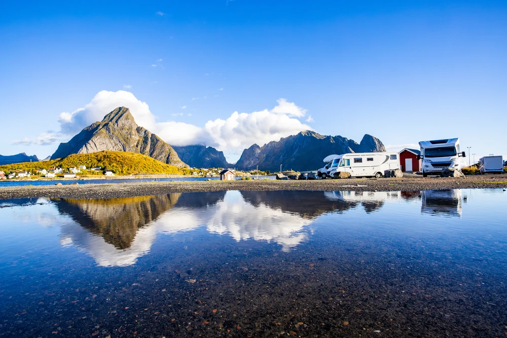 Motorhomes parked by the water, with the mountains reflected in Lofoten