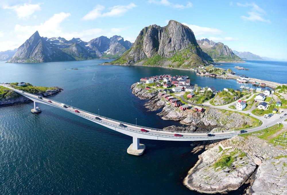 Bridge over the sea to a fishing village beneath steep peaks in Lofoten